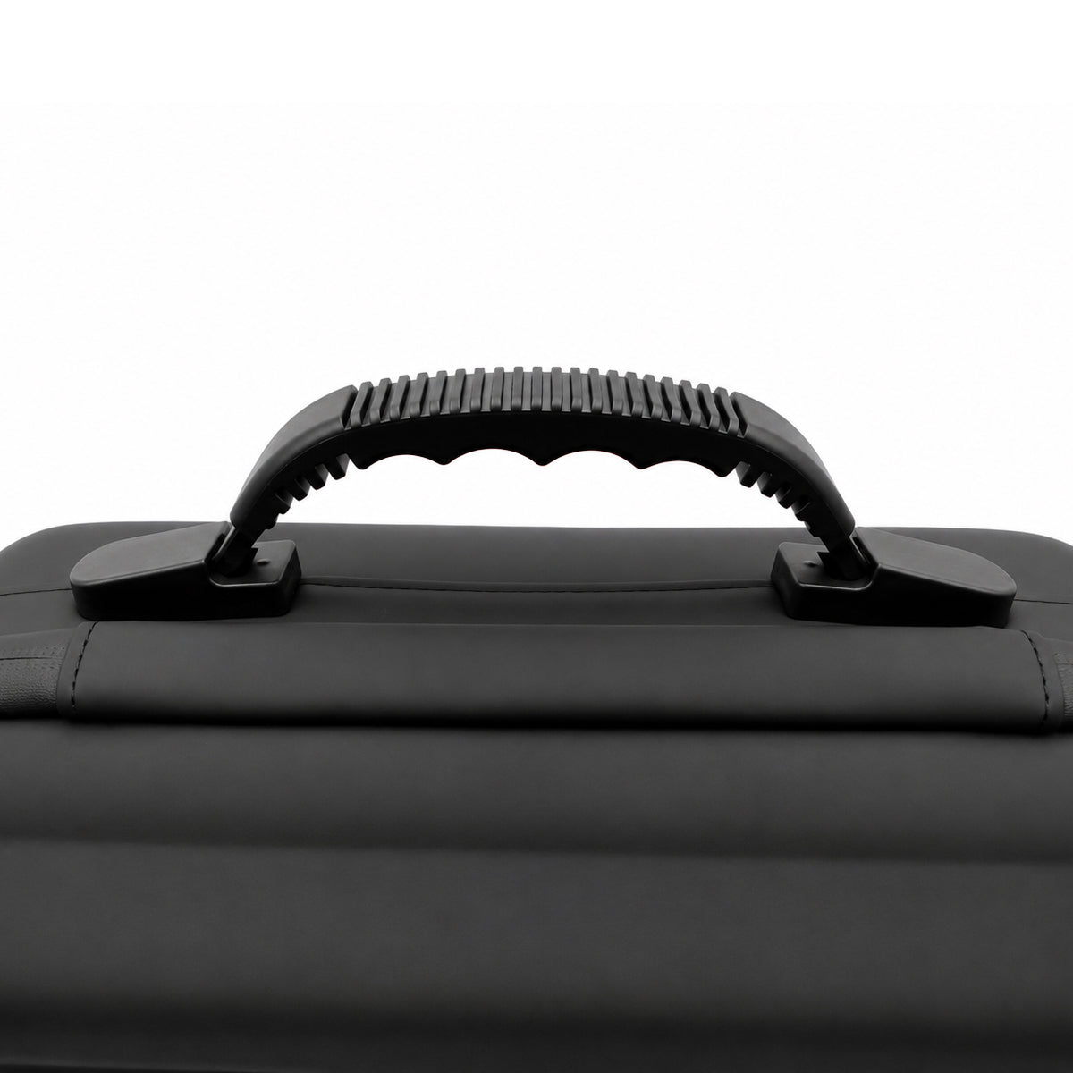 Close-up of a black hard-shell case handle with a textured grip, mounted on a black case against a white background.