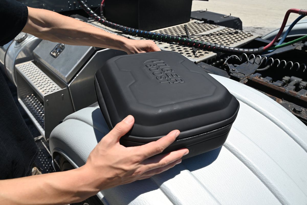 A person holding a black protective hard case with the branding &